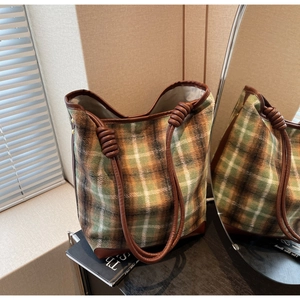 Detailansicht der grünen karierten Woll-Tote-Bag mit gedrehtem Lederriemen und Eckenschutz
