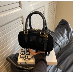 Dettaglio della borsa Boston nera opaca con forma a cilindro e finiture dorate