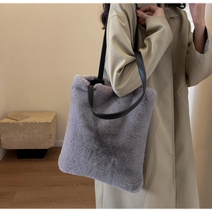 Détail du sac cabas en fausse fourrure grise avec de longues anses en cuir noir