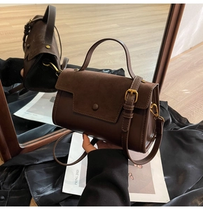 Detailed view of dark brown retro crossbody bag with matte finish and metal buckle