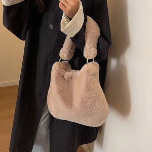 Fuzzy faux fur tote bag in light brown with golden metal rings shown on a model