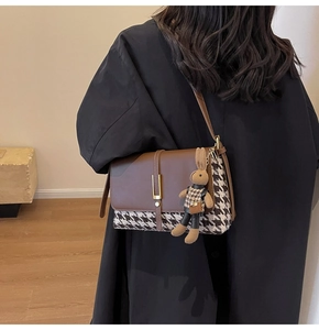 Detail of crossbody tote bag in brown leather and houndstooth with plush bunny charm