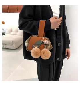 Detailed shot of brown corduroy Boston bag with plush cherry pom-poms and leaf charms