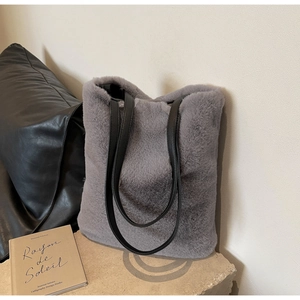 Détail macro du sac cabas en fausse fourrure grise avec anses premium en cuir noir