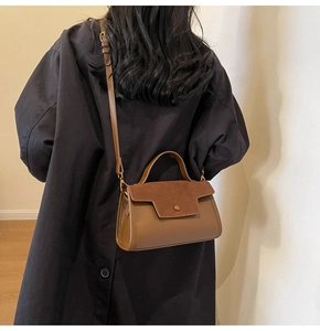 Rear view of a vintage brown crossbody bag with suede-like texture and top handle