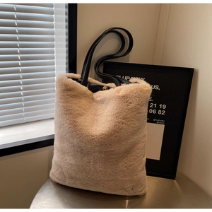 Détail du grand sac cabas en peluche beige avec anses en cuir noir et fermoir magnétique