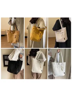 Bolsos tote grandes de lona en cuatro colores que muestran opciones de transporte al hombro