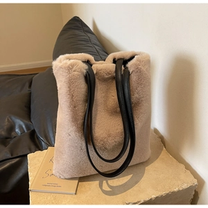 Détail d'un sac cabas en fausse fourrure beige avec des anses en cuir noir