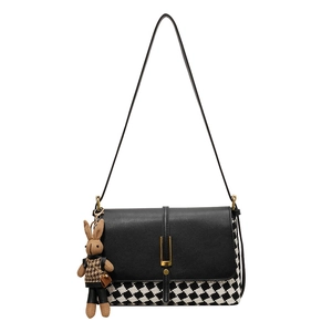Women's black tote bag with checkered panel and cute plush rabbit charm on white background