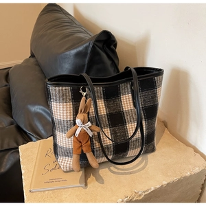 Detail of tweed tote bag with three-color plaid fabric and brown rabbit charm