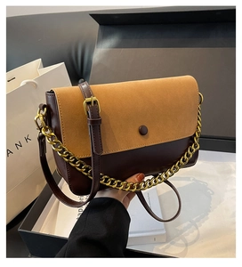 Detail of vintage patchwork shoulder bag with gold chain and dark brown leather texture