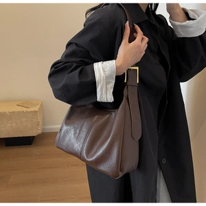 Detailed texture of dark brown faux leather tote with elegant gold metal buckle