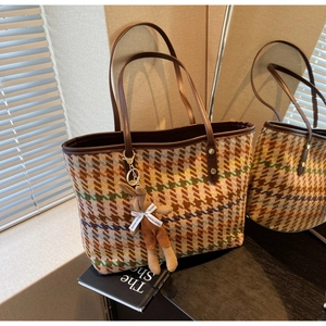 Detailed shot of brown houndstooth tote bag with colorful stripes and rabbit pendant