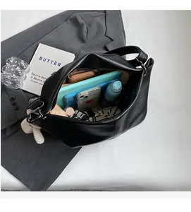 Spacious interior of black leather tote bag holding tablet, wallet, and essentials