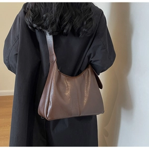 Deep brown leather hobo bag styled with a wool coat for a chic professional look