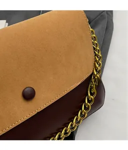 Detail of vintage flap bag showing contrast suede and leather textures with gold chain