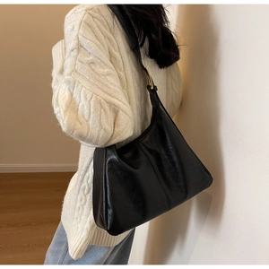 Detail of black PU leather tote bag showing fine texture and gold adjustment buckle