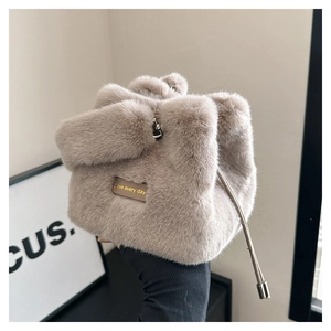 Detailaufnahme der flauschigen Winter-Beuteltasche mit braunem Lederetikett und Golddruck