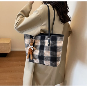Detailed back view of a large plaid tote bag with a brown rabbit plush charm on a shoulder strap