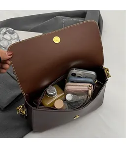 Detailed interior of brown leather crossbody bag showing large capacity for essentials