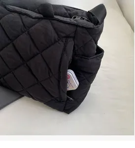 Detail der schwarzen gesteppten Canvas-Tasche mit funktionalem Seitenreißverschlussfach