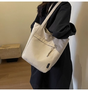Detalle del bolso tote de lona con tirador de cremallera tejido y etiqueta con logo