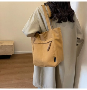 Vista lateral del bolso tote de lona amarilla grande con correas anchas y bolsillo