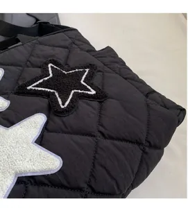 Detail der schwarzen Stepptasche mit einem flauschigen sternförmigen Stickerei-Patch