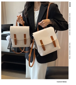 Detail eines beige Mini-Rucksacks mit braunen Gurten, Goldschnallen und Plüsch-Anhänger