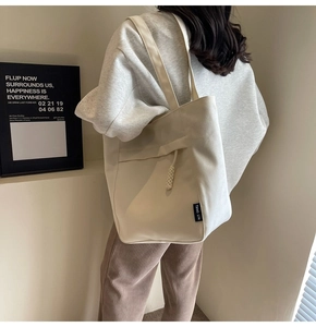 Bolso tote grande de lona blanca en modelo con correas de hombro y detalles de cuerda