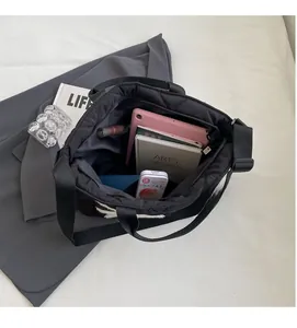 Draufsicht auf die große schwarze Stepptasche mit geräumigem Innenraum und Zubehör