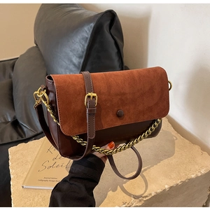 Close-up of vintage brown leather crossbody bag with suede flap and gold chain detail