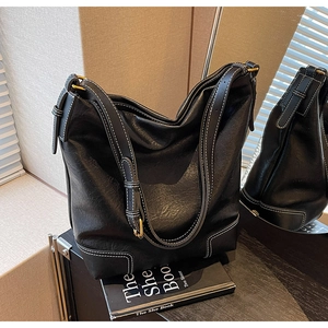 Détail du sac cabas en cuir noir avec surpiqûres blanches et boucle dorée élégante