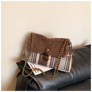 Close-up of brown faux shearling and plaid fabric texture with gold chain strap