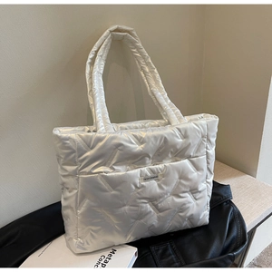 Detail view of a white quilted tote bag featuring a minimalist FASHION&BAG label