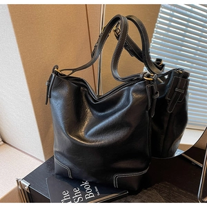 Détail d'un sac seau vintage noir avec surpiqûres blanches et texture aspect cuir huilé