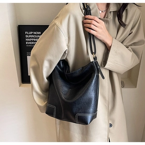 Détail du grand sac seau noir avec surpiqûres blanches contrastées et bandoulière réglable