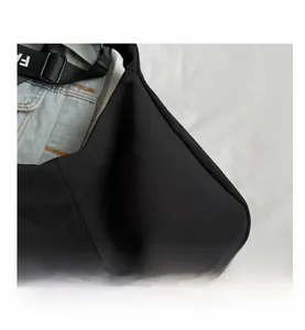 Gros plan d'un sac cabas en toile noire avec détails de couture et bandoulière lettrée