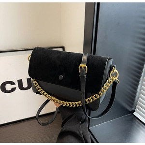 Detail of black crossbody bag featuring suede textures and gold chunky chain strap