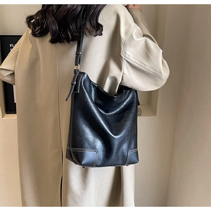 Détail du sac seau noir avec surpiqûres blanches contrastées et bandoulière réglable