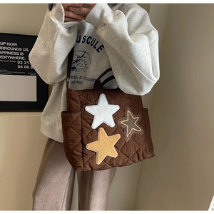 Detail der kaffeebraunen Stepptasche mit Plüschsternen und praktischer Seitentasche