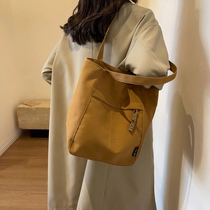 Bolso tote de lona amarillo mostaza para mujer con bolsillo frontal y nudo trenzado