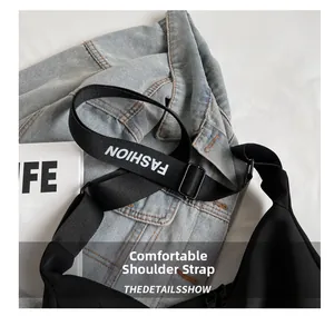 Gros plan sur la bandoulière large en toile noire avec texte FASHION blanc imprimé