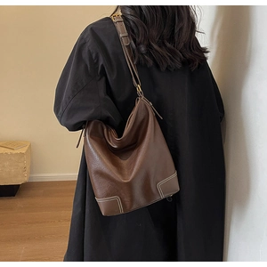 Sac seau marron foncé avec coutures contrastées aux coins et bandoulière réglable