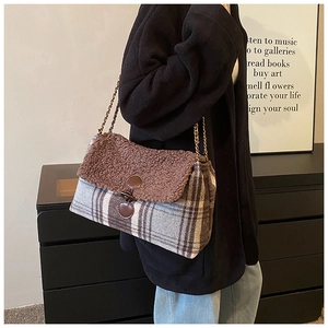 Detail of grey plaid tote bag with brown plush flap and metal chain strap for women