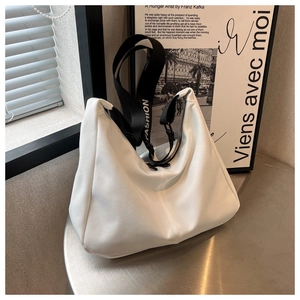 Détail du sac plissé blanc avec bandoulière large FASHION noir et blanc sur table