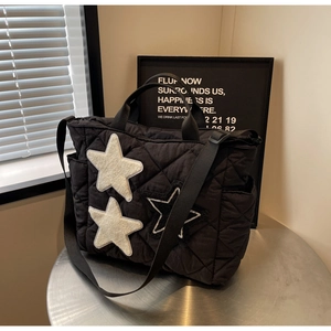 Detail der schwarzen Stepp-Tote-Bag mit Stern-Patches und verstellbarem Schultergurt