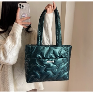 Detail of green quilted tote bag showing metallic texture and FASHION&BAG label