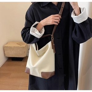 Vue détaillée du sac seau crème et marron avec texture lychee et coutures précises