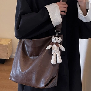 Large dark brown hobo tote bag with a cute white teddy bear pendant for autumn style